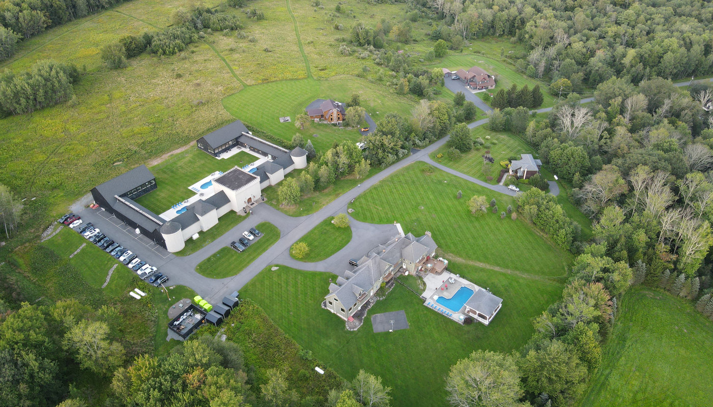 Aerial view of the Hilltop Castle World compound: four houses on 130 shared acres in the Pocono Mountains