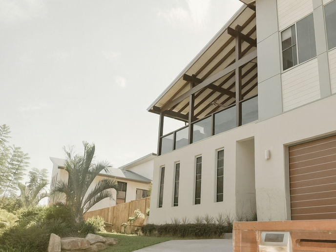 Modern two-storey home built by AllSpec Projects in Mudgeeraba, featuring a balcony with timber beams and landscaped garden