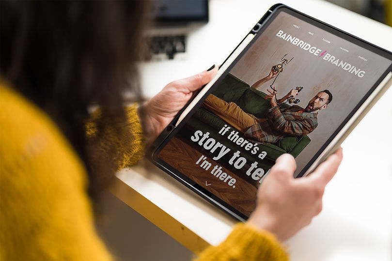 Website mockup for Bainbridge Branding, featuring an image of Steph looking at her iPad, showcasing the brand's design elemen