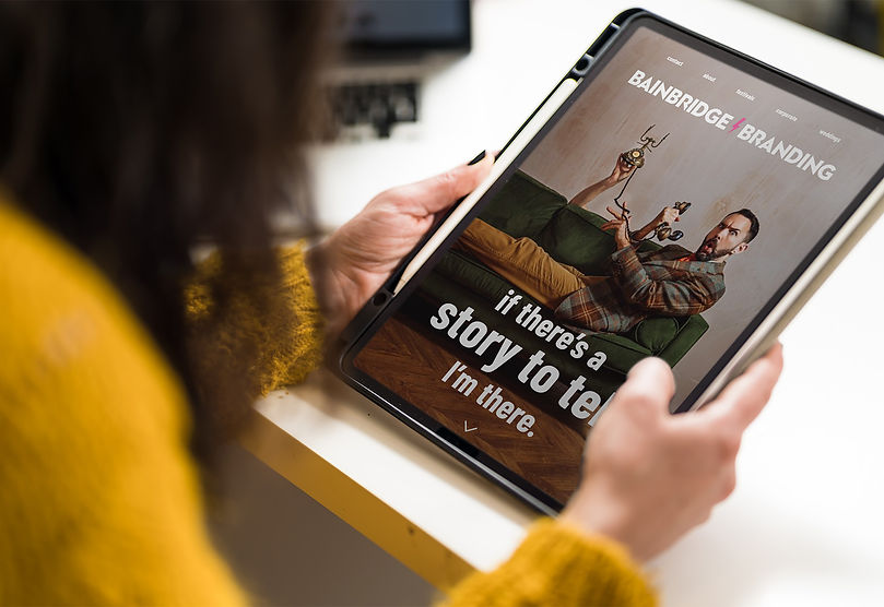 Website mockup for Bainbridge Branding, featuring an image of Steph looking at her iPad, showcasing the brand's design elemen
