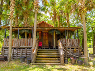 Rustic cabin rental in Escambia County, Florida surrounded by trees, offering a peaceful stay near the Blackwater River and outdoor nature setting.