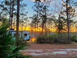 RV camping site in Escambia County Florida at sunset near the Blackwater River surrounded by trees and natural scenery