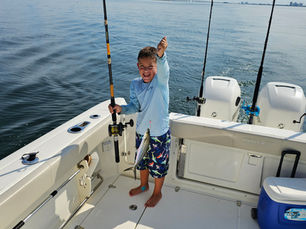 a kid holding a fish with Fishing In Paradise Charters