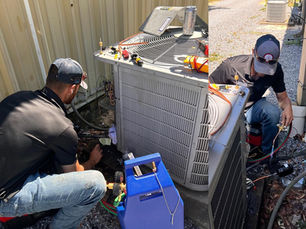 HVAC technicians repairing residential air conditioning unit in Pensacola FL