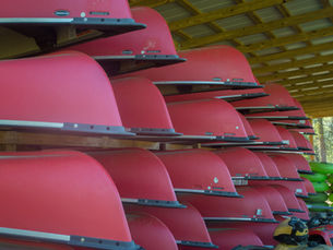 Kayaks and canoes stacked and ready for kayak and canoe float trips in Okaloosa County, showcasing rental equipment prepared for river adventures with Blackwater Joe’s Canoes.