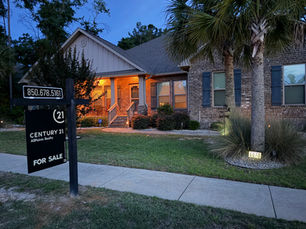 Real estate sign installed in a residential yard near Fort Walton Beach, Florida