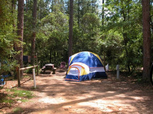 Tent camping site in Escambia County Florida with a pitched tent in a shaded wooded area near the Blackwater River