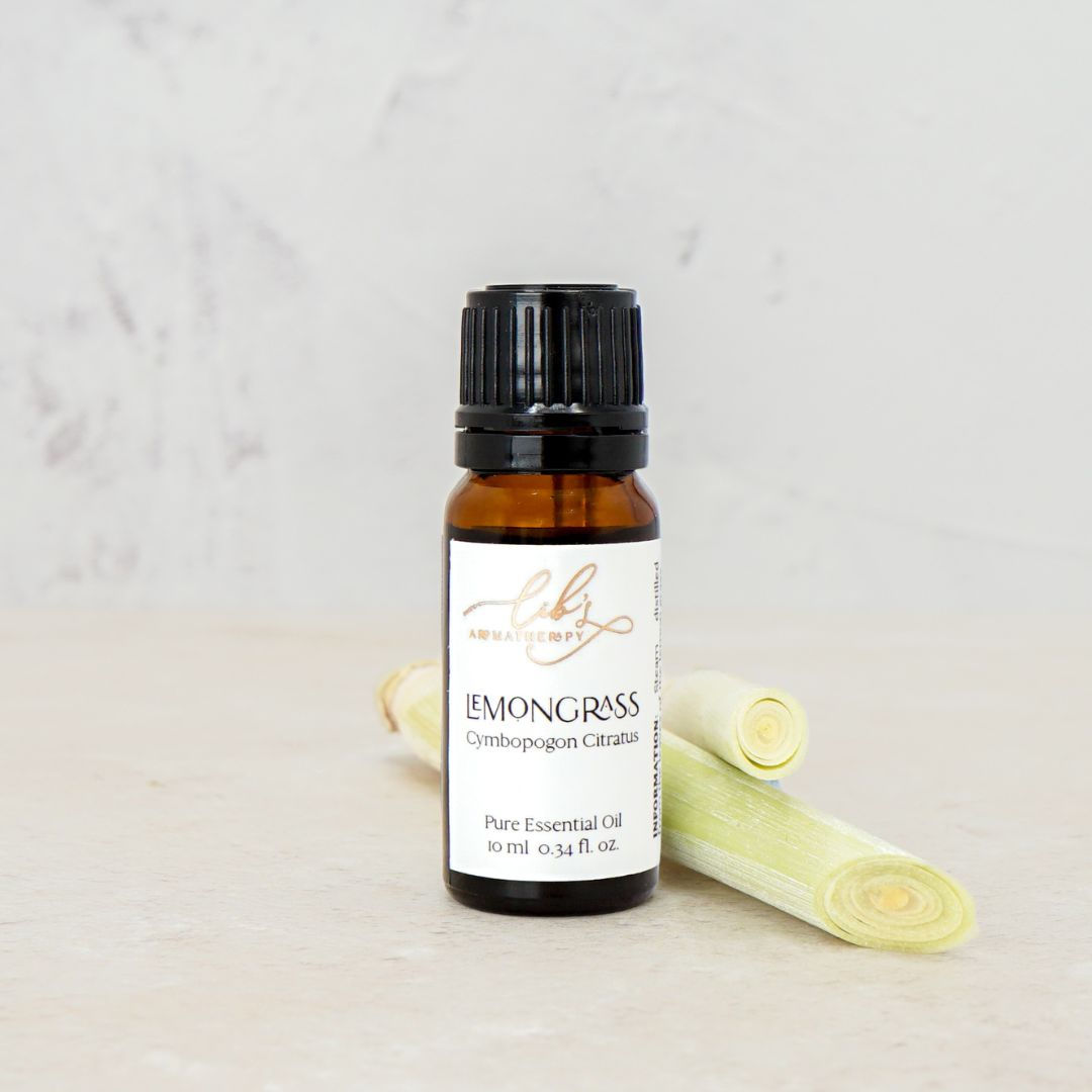 Lemongrass essential oil bottle next to some lemongrass