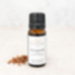 Cedarwood essential oil bottle styled with cedarwood pieces