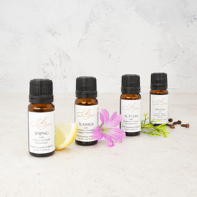 Seasonal essential oils displayed with flowers and botanicals.
