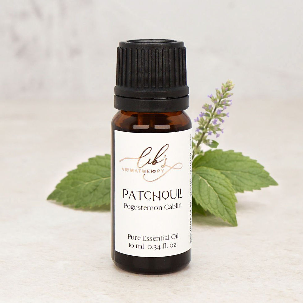Patchouli essential oil bottle styled with fresh green leaves