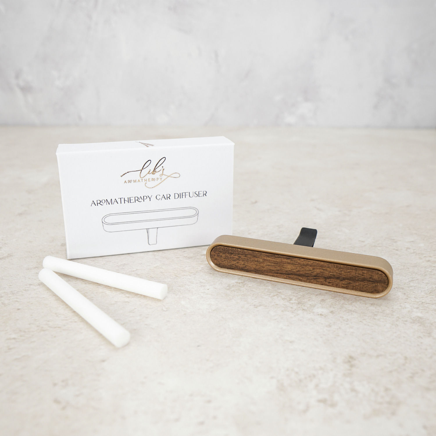 Car vent diffuser with replacement fibre wicks and packaging by Lib’s Aromatherapy on a neutral background