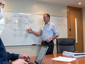 John Hannan in a conference room reviewing DSCSA related workflows on a whiteboard