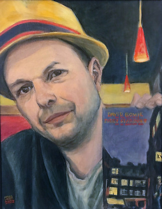Portrait of Paul. A man with a yellow hat holding a record lf Ziggy Stardust
