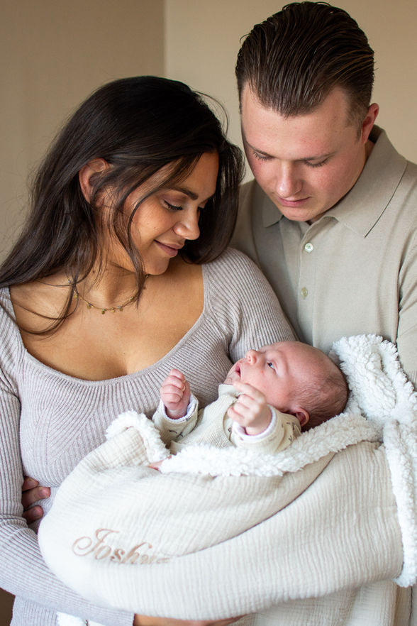 Papa en mama met pasgeboren zoontje in dekentje