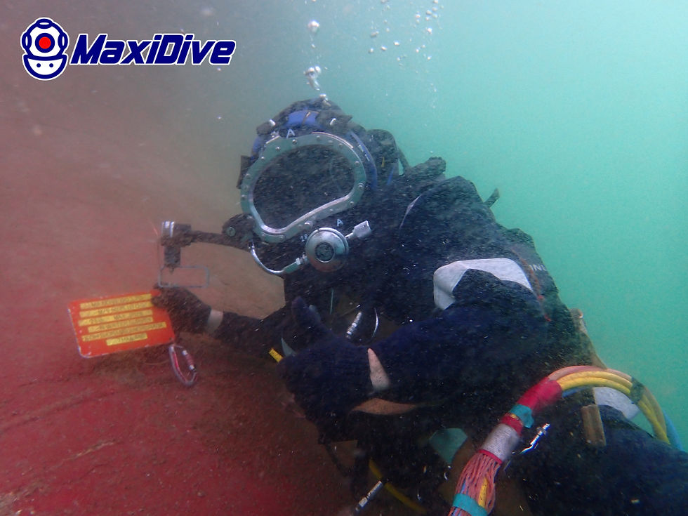 Commercial diver documenting underwater hull condition with measurement tools during MaxiDive in-water survey in Thailand