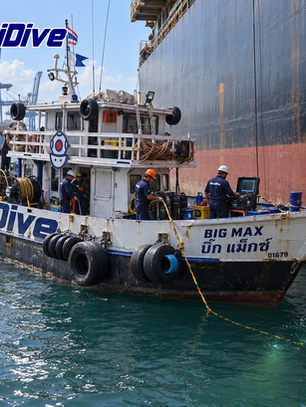 Bow view of a MaxiDive support boat alongside a vessel on open water.