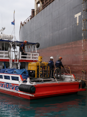 Commercial diving team supporting underwater hull inspection of a vessel in Thailand