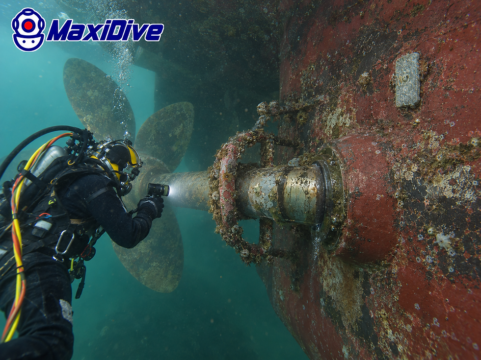 Commercial diver inspecting stern tube external area and visible propeller shaft beneath commercial vessel