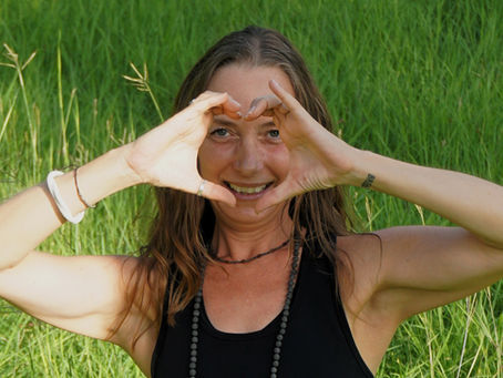 Nat smiling through a heart shape she made with her hands
