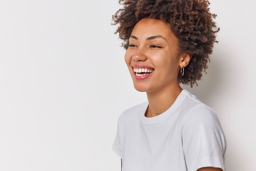 woman-with-curly-hair-smiles-broadly-shows-white-teeth-dressed-casual-t-shirt-isolated-whi