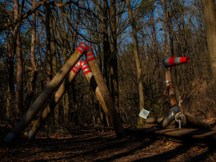 Houten palen in vorm van een stokkenman in het bos