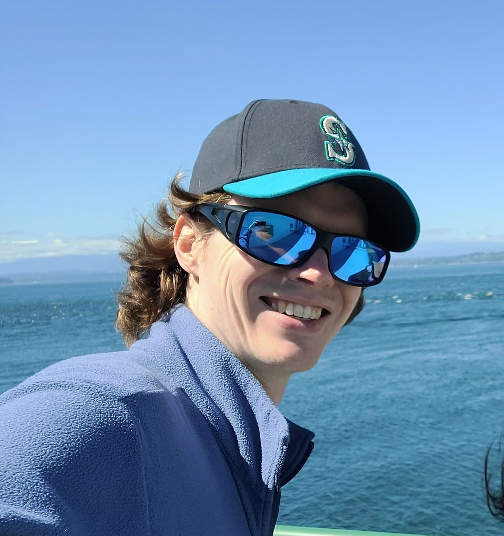 Chris Floyd smiling with sunglasses and a Seattle Mariners hat on