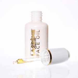A bottle of Lacréme Beauté face oil with the dropper and lid resting in front of it