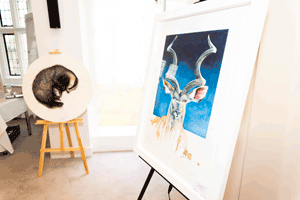 In the front a painting of a stag and in the background a piece depicting a badger