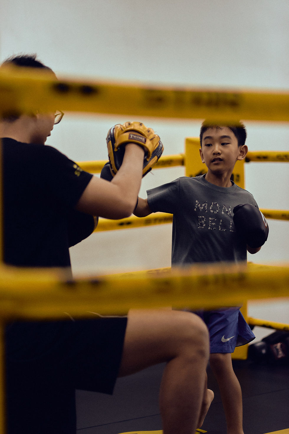 A young boy practicing boxing with a trainer