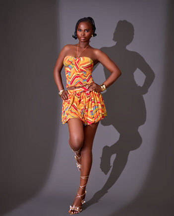 black woman wearing an orange bubble skirt set from seta the label 