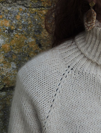 Detail of a raglan seam on a hand knit luxury sweater, made by hand out of noble materials including pure wool, silk, mohair.