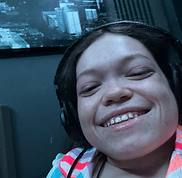 Close-up selfie of singer-songwriter Gracie Moyes smiling while wearing headphones.