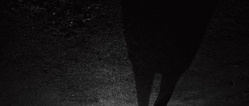Dark silhouette of a person walking at night