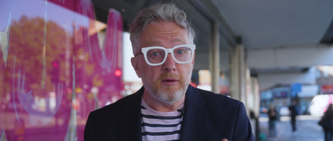 Man in glasses speaks outdoors