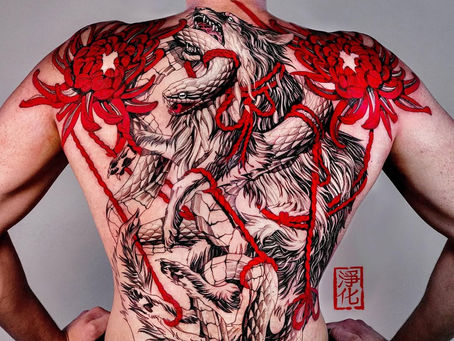 Full back tattoo of a roaring wolf and snake intertwined with red rope and spider lilies, by guest artist Junghwa from South Korea at Hammersmith Tattoo London