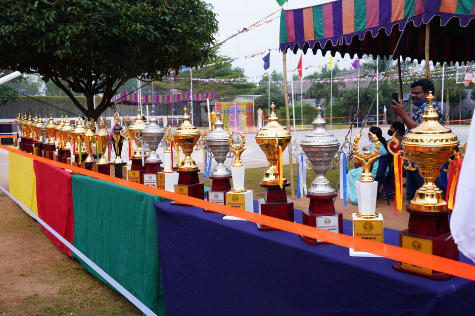 A line of trophies on a table, awards ceremony on campus.