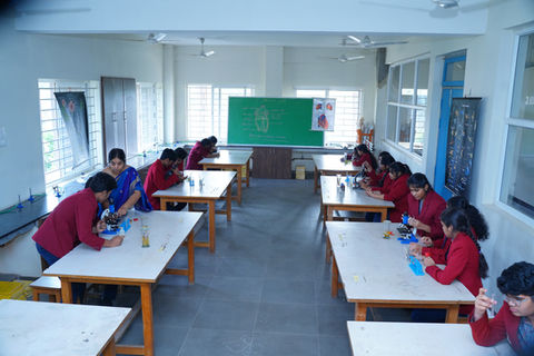 Students in red uniforms doing experiment at Future Kids Global School