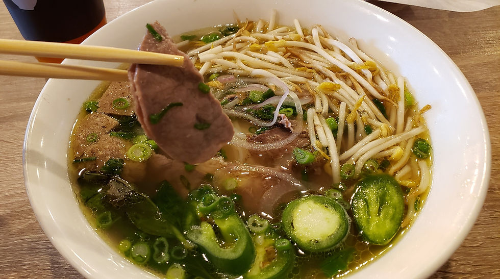 combo pho bowl with slice of beef in chop sticks