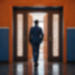 Man in blue suit walking away from a lowball job offer through ornate orange doors