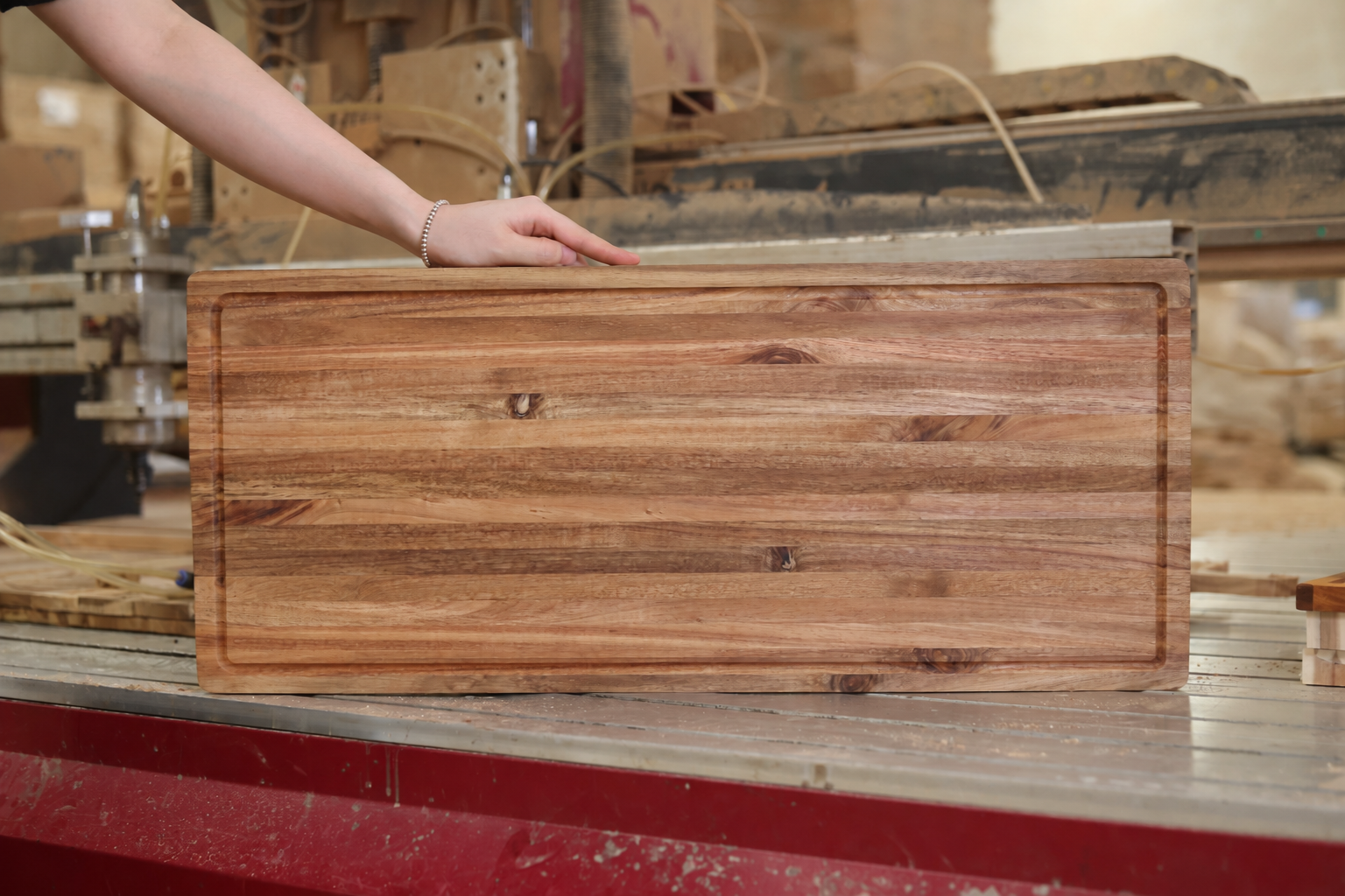 Long rectangular wooden cutting board with a routed perimeter groove