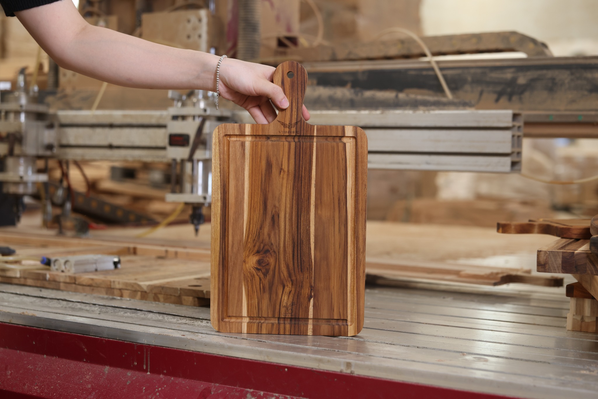 Paddle cutting board with natural grain, a handle hole and perimeter groove