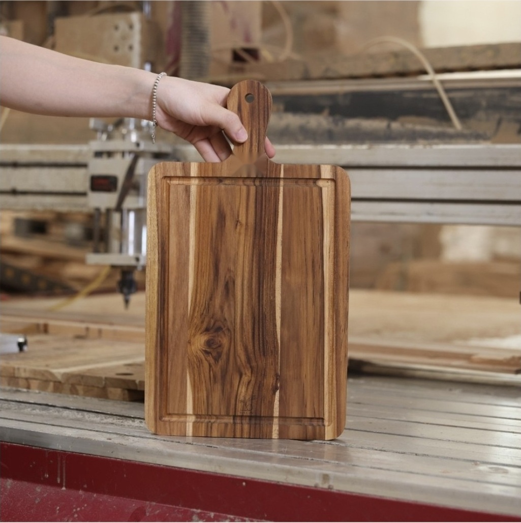 Upright paddle cutting board showing its handle profile and natural grain