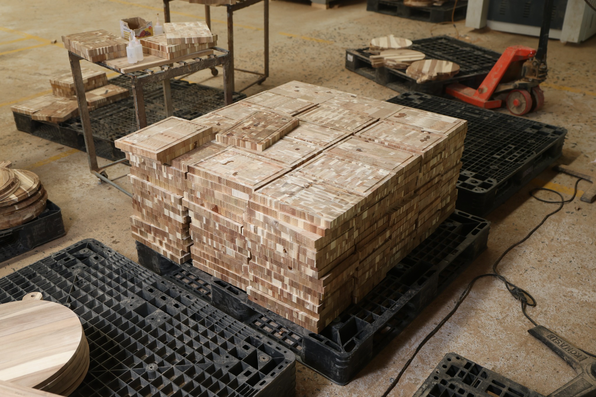 Unfinished acacia cutting boards stacked during factory production in Vietnam