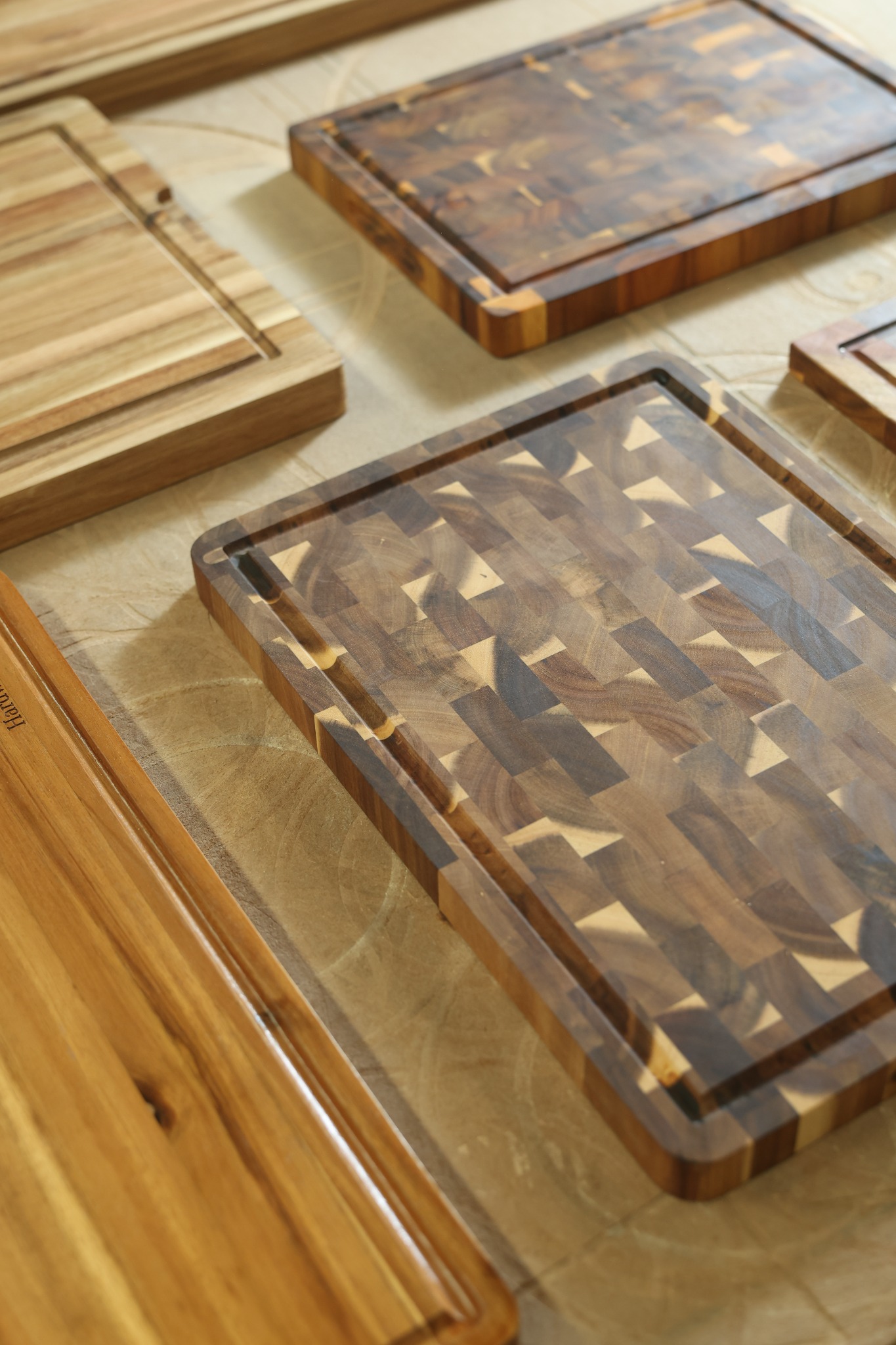 End-grain wooden cutting board with a contrasting block pattern and perimeter juice groove in our Vietnam factory