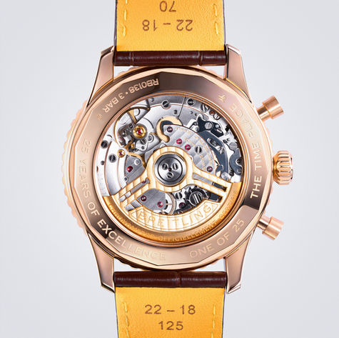 Macro product shot of gold chronograph watch showcasing movement and caseback design