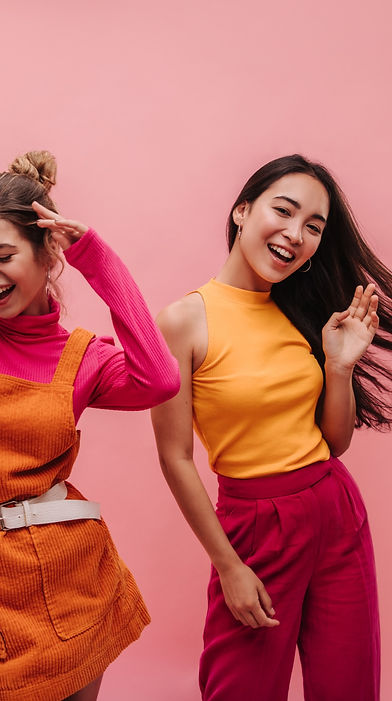 Copy of Energetic young two interracial girls dancing side by side and waving hands in stu