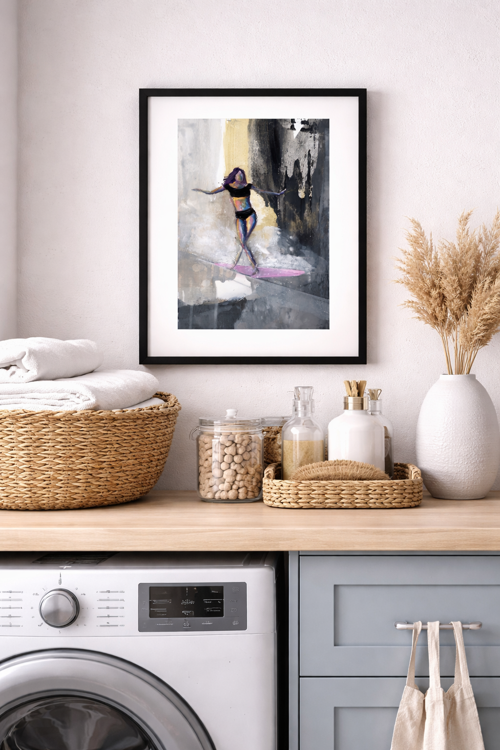 Elegant surfer mini print in a black 8x10 frame with white mat, styled in a coastal laundry room with woven baskets, folded t