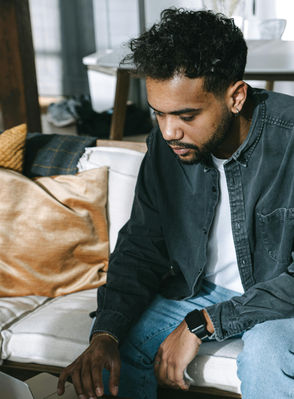 Young man sitting in the couch and working from home on his laptop