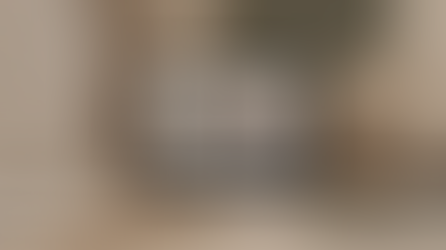 A modern, editorial-style workspace scene featuring a laptop displaying a sleek, interactive website interface with soft motion elements.